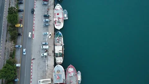 Aerial top down view of coastal road and fishing boats at harbor Stock Footage 337462789