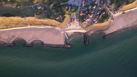 Aerial Top-Down View of Coastal Village, Beach and Breakwaters Stock Footage 343515930