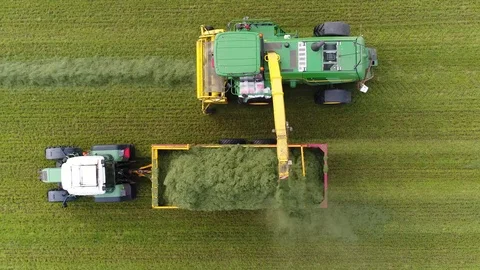 Aerial top down view combine harvester unloading in tractor 4k Stock Footage 105860452