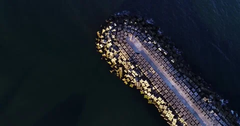 Aerial top down view of a concrete breakwater jetty protecting the harbor e.. 库存影片 327872987