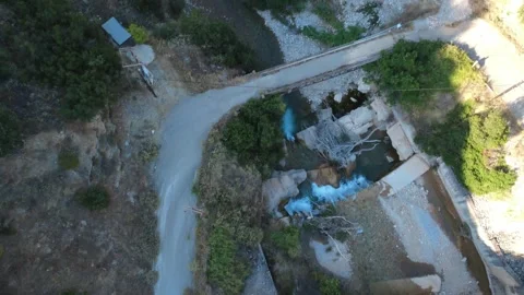 Aerial top down view of a concrete bridge crossing over a rushing river Stock Footage 343960850