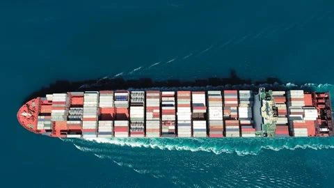 Aerial top down view of a container ship. Her engine roaring at full speed Stock Footage 258628383