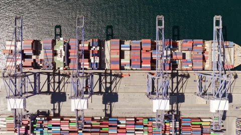Aerial top down view of container ship unloading cargo at a commercial port Stock Footage 345007034