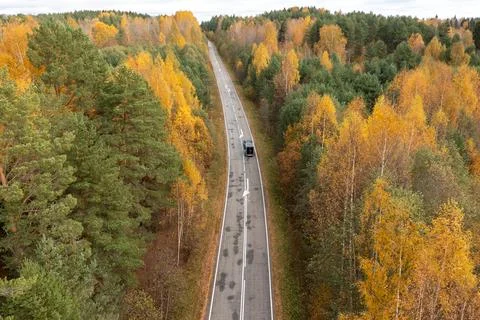 Aerial top-down view of a dark car with a small trailer driving along a Stock Photos