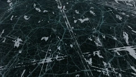 Aerial top down view of deep cracked ice patterns and snow on Lake Baikal Stock Footage 347235153