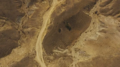 Aerial top down view dirt road around sandy rocky yellow landscape Stock Footage 118741907