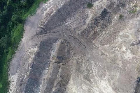 Aerial top-down view of disturbed land, curved haul road tracks Stock Photos