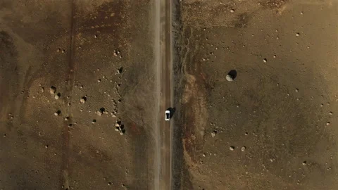 Aerial top down view drone of car driving on gravel road in iceland desert Stock Footage 205359207