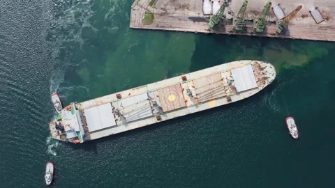 Aerial top down view from drone a dry cargo grain vessel leaves the sea port Stock Footage 238694887