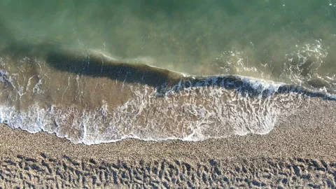 Aerial top down view drone ascending over beach with clear greenish sea waves. Vídeos de archivo 347738048