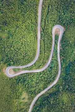 Aerial top down view drone image of curvy mountain road asphalt with serpenti Stock Photos