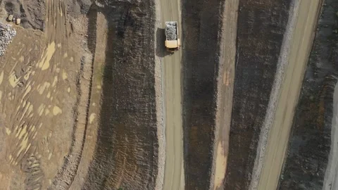 Aerial top-down view of a dump truck transporting ore in a quarry Видео 343843836