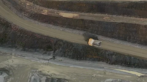 Aerial top-down view of a dump truck driving in a quarry Видео 343844341