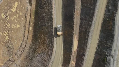 Aerial top-down view of a dump truck driving in a quarry Видео 343845402