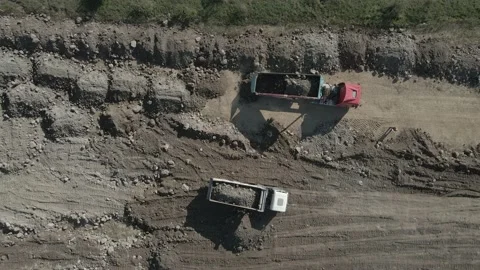 Aerial top down view of a dumper trucks unloading the gravel. 2 dump trucks Stock Footage 141611343