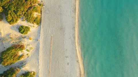 Aerial top down view of the empty beach and the sea at sunrise Stock Footage 111875922