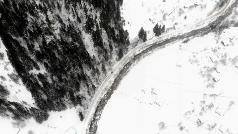 Aerial - Top down view of empty road between the snowy pine trees Stock Footage 126241359