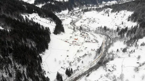 Aerial - Top down view of empty road between the snowy pine trees Видео 126243458
