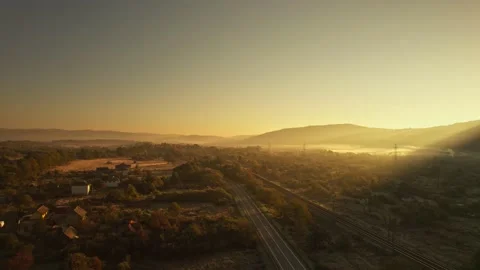 Aerial top down view empty asphalt road and railways at sunny sunrise in country Stock Footage 195112009