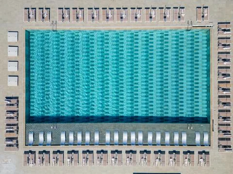 Aerial top down view of an empty resort swimming pool with sunbeds Foto stock