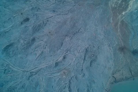 Aerial top down view of eroded mountain slope texture near blue lake. Rugged Foto stock
