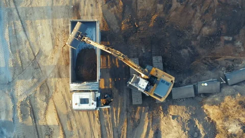 Aerial top down view of an excavator loading soil into a truck on a development Stock Footage 165421836