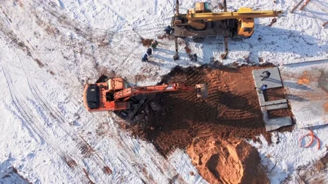 Aerial top down view. Excavator loads dump truck with earth on winter day. Vidéo 233153689