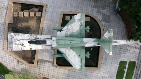 Aerial top down view of a fighter jet on display surrounded by beautiful landsca Stock Footage 133673626