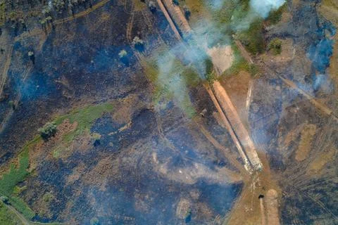 Aerial Top Down View of Fire Aftermath and Active Smoke. Scorched Earth with Stock Photos