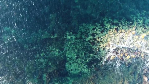 Aerial top-down view flying to right over azure blue ocean and rocks 4k Stock Footage 83926484