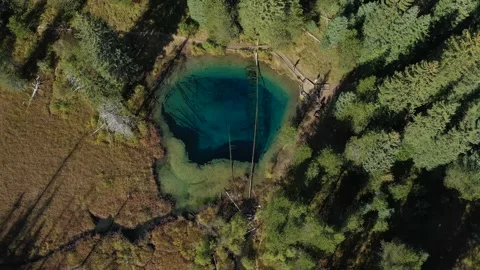 Aerial top down view flying past Little Crater lake with clear blue water Видео 201036469