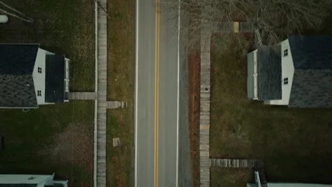Aerial top down view flying above a quiet american suburban road where girl is Vídeo Stock 334100434