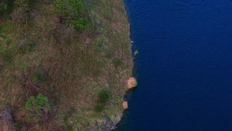 Aerial top down view flying over a lake shoreline Stock Footage 339377596