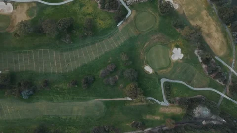 Aerial top-down view flying over a lush green golf course Видео 342574811