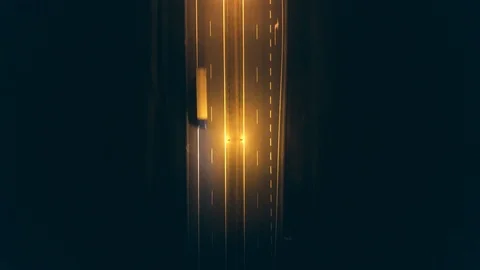 Aerial top-down view of a foggy car road at night Stock Footage