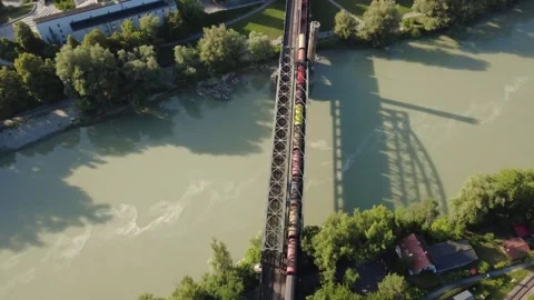Aerial top down view of a freight train crossing the Inn river bridge Vídeo Stock 340004664