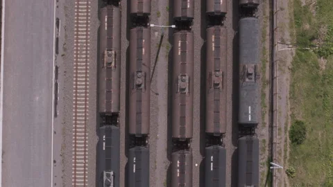 Aerial top down view of freight trains moving slowly along the tracks at the Stock Footage 345904726