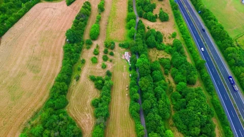 Aerial top-down view of a German autobahn running past a scrubby meadow with Stock Footage 342247486