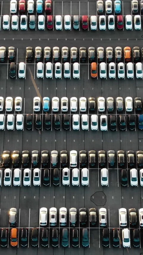 Aerial top down view of a giant car park revealing rows of new vehicles, an Stock Footage 345204379
