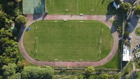 Aerial top down view of green empty football field with running track. Stock Footage 153685039