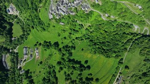 Aerial top-down view of green Pyrenees hillside with scattered houses, meadows Video stock 337984739