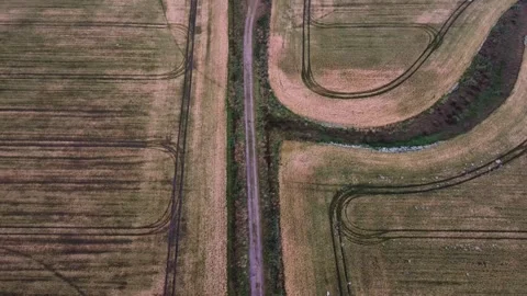 Aerial Top-Down View of Harvested Fields with Tractor Tracks on Romo, Denmark Stock Footage 332134359