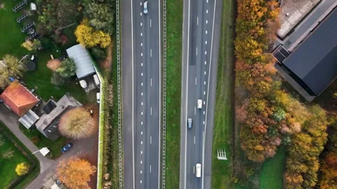 Aerial top-down view of highway traffic in autumnal landscape Stock Footage 323384378