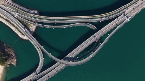 Aerial top down view of highway interchange over turquoise water Stock Footage 329556228