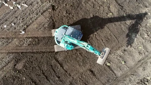 Aerial top-down view of hydraulic excavator driving over brown soil 4k Stock Footage 74893906