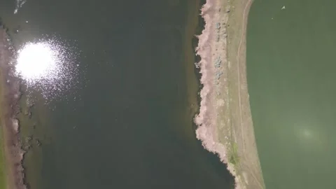 Aerial top-down view of a hydraulic structure and pond Stock Footage 337884258