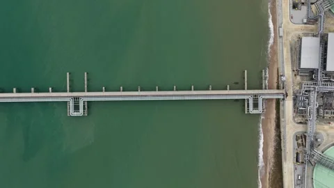 Aerial top down view of industrial pipeline and pier extending over the sea Stock-Footage 329090493