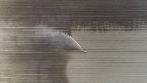 Aerial top down view of irrigation sprinkler distributing water over dry soil 4k Vídeo Stock 78035975