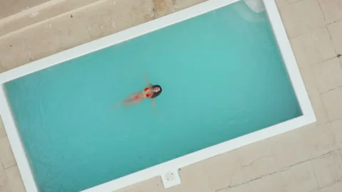Aerial top down view isolated beautiful brunette woman in red bikini float Stock Footage 253136336