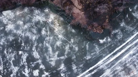 Aerial top down view of a lake with thin melted ice on the surface. Stock Footage 180560230